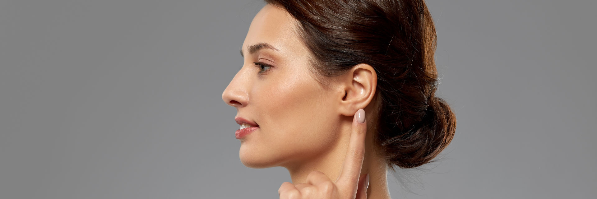 A beautiful woman pointing at her ear.